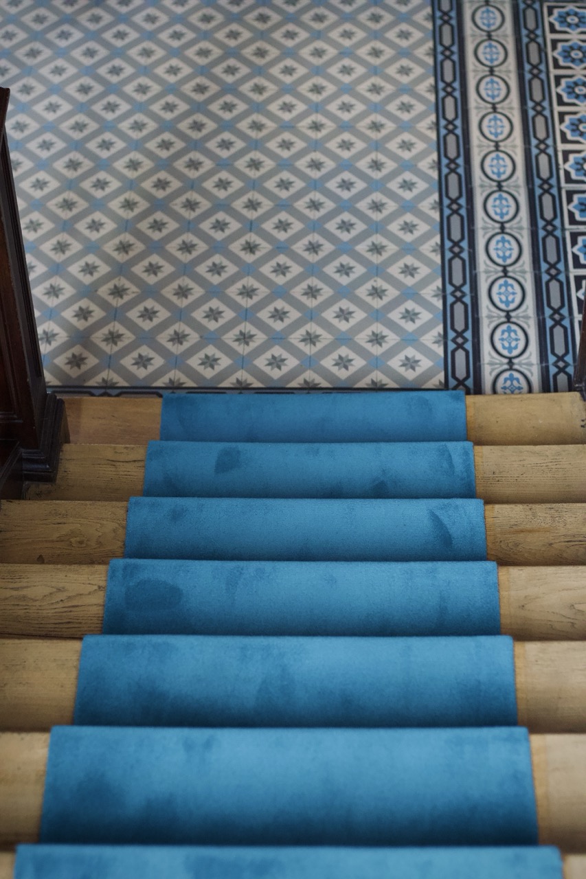 Tapis d'escalier bleu avec marche en bois