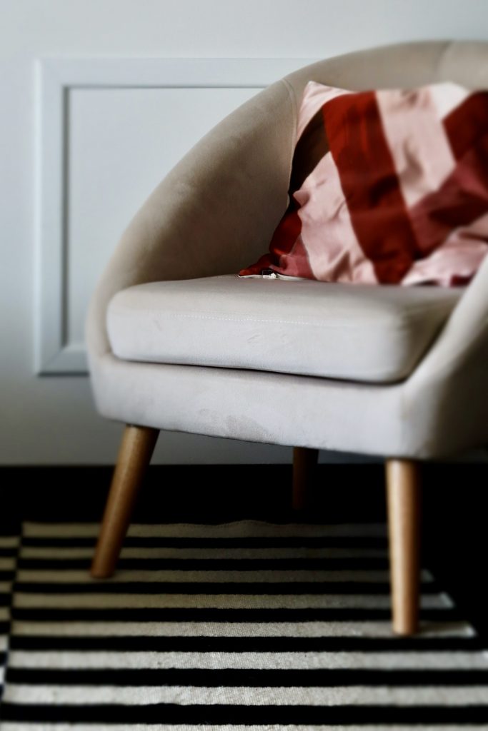 Projet Georges - fauteuil gris avec coussin rouge, tapis rayé noir et blanc