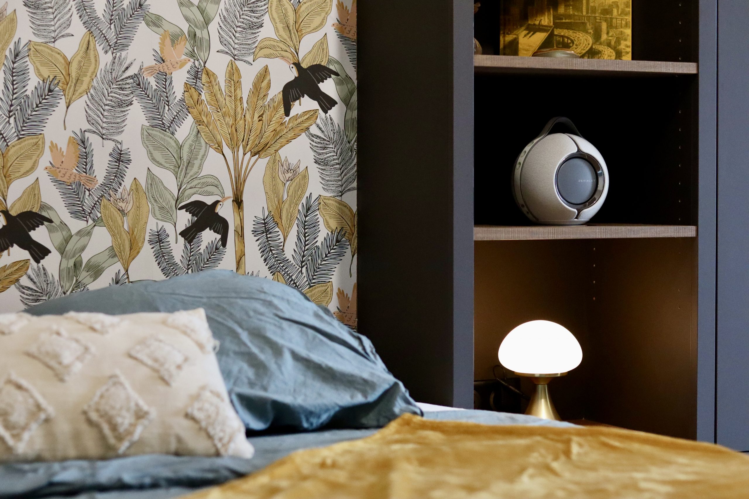 Projet Charlie - chambre avec étagère en bois, lit et lampe, papier peint fleuri