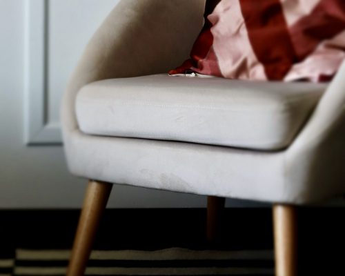 Projet Georges Projet Georges - fauteuil gris avec coussin rouge, tapis rayé noir et blanc
