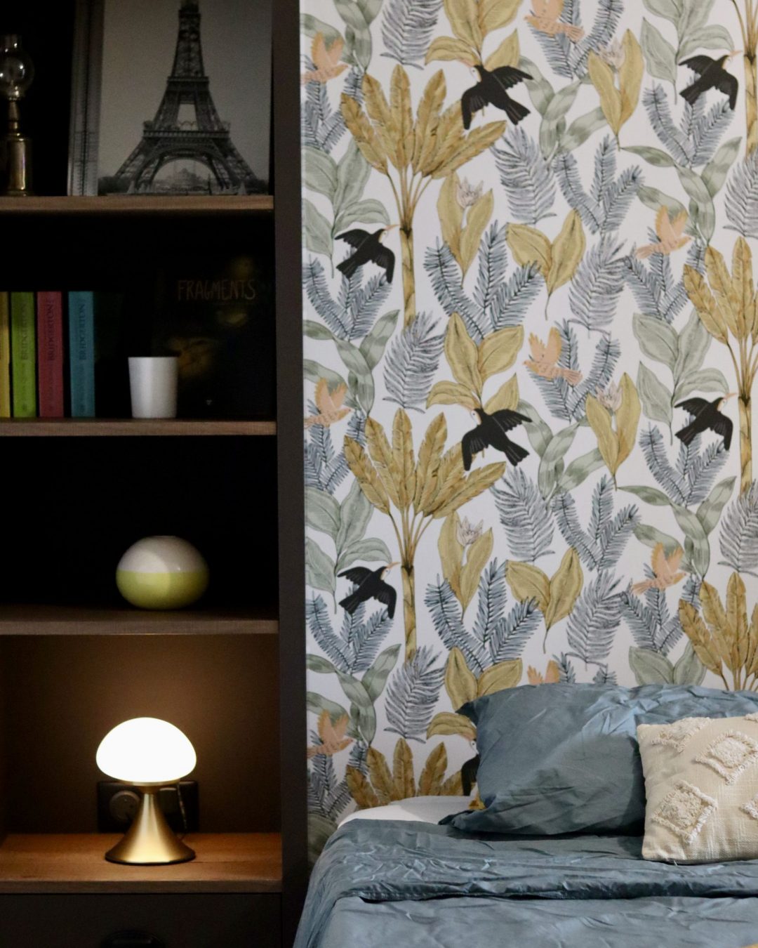 Projet Charlie - chambre avec étagère en bois, lit et lampe, papier peint fleuri